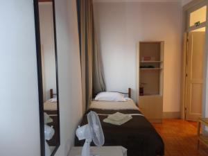 a hotel room with a bed and a mirror at Portuense Alojamento Local in Porto