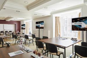 a conference room with tables and chairs and a projection screen at Delta Hotels by Marriott Durham Royal County in Durham