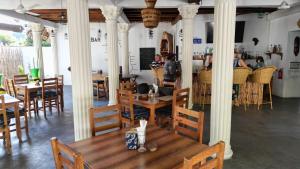 a restaurant with tables and chairs and people sitting at tables at little pompeji boutique hotel - adults only in Jambiani