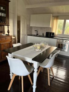 una cucina con un tavolo con sedie bianche e un tavoloasteryasteryasteryasteryastery di S' Ispantu a Olbia