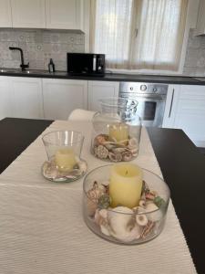 un tavolo con tre candele e conchiglie in una cucina di S' Ispantu a Olbia