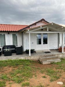 una casa bianca con un portico con sedie e finestre di S' Ispantu a Olbia Altre 4 foto