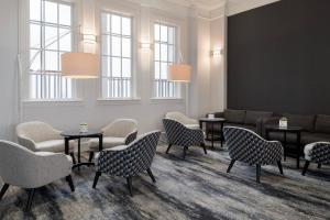 a waiting room with chairs and tables and windows at Delta Hotels by Marriott Heathrow Windsor in Windsor