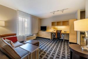 a living room with a couch and a desk in a room at TownePlace Suites by Marriott Vincennes in Vincennes