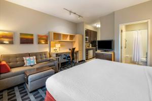 a hotel room with a bed and a couch at TownePlace Suites by Marriott Vincennes in Vincennes
