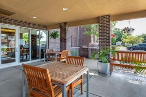 a patio with a wooden table and chairs at TownePlace Suites by Marriott Vincennes in Vincennes