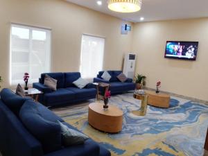 a living room with blue couches and a tv at Ibiza Hotel & Resorts in Aba
