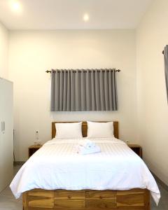 a bedroom with a large bed with white sheets at Bulan Biru in Kuta Lombok