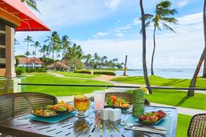 Sheraton Kauai Resort Villas في كولو: طاولة مع الطعام والمشروبات والمحيط