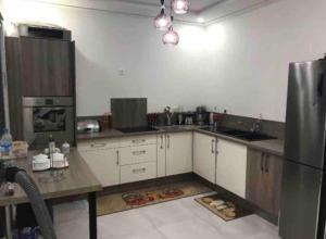 a kitchen with white cabinets and a stainless steel refrigerator at villa aya in Saïdia