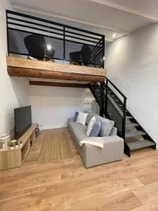 a living room with a couch and a loft bed at Duplex sous les toits in Riez
