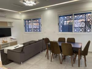 a living room with a couch and a table and chairs at villa aya in Saïdia