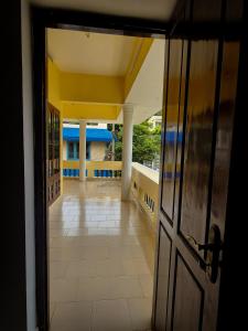 eine offene Tür zu einem Balkon mit Blick auf ein Zimmer in der Unterkunft Urban Haven Short Stays in Thiruvananthapuram