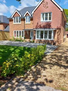 a large brick house with a driveway at Oakwood in Lymington