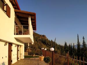 ein Gebäude mit einem Balkon und einem Zaun mit einem Berg in der Unterkunft Lilaia's View in Lílaia