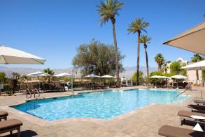 a pool with chairs and umbrellas at a resort at The Westin Mission Hills Resort Villas, Palm Springs in Rancho Mirage