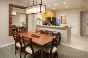 uma sala de jantar e cozinha com mesa e cadeiras de madeira em The Westin Mission Hills Resort Villas, Palm Springs em Rancho Mirage