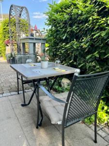 einem Picknicktisch mit 2 Stühlen und einem Tisch mit Weingläsern in der Unterkunft Hotel Schwarzwälder Hof Achern in Achern