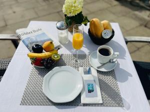 einen Tisch mit einem Teller Essen und einer Tasse Kaffee in der Unterkunft Hotel Schwarzwälder Hof Achern in Achern
