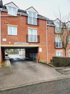 um grande edifício de tijolos vermelhos com estacionamento em RGM Hatfield 2 Bedroom Apartment em Hatfield