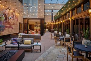 un patio al aire libre con mesas, sillas y luces en Hotel Clio, a Luxury Collection Hotel, Denver Cherry Creek, en Denver
