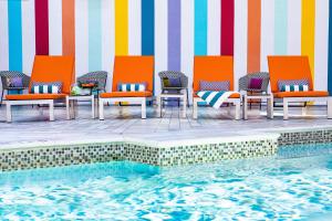 a group of chairs sitting next to a swimming pool at Hotel Colee, Atlanta Buckhead, Autograph Collection in Atlanta