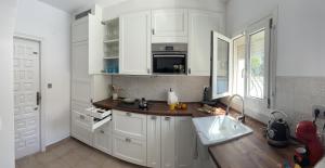 una cocina con armarios blancos y fregadero en La Duna de Denia, en Denia
