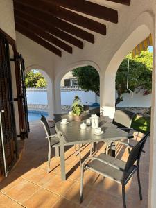 una mesa y sillas en un patio con vistas al agua en La Duna de Denia, en Denia