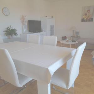una mesa blanca y sillas en la sala de estar. en Baraban en Primošten