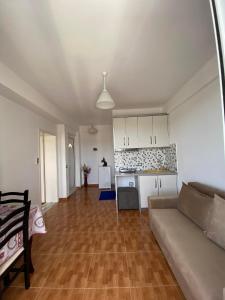 a living room with a couch and a kitchen at Seafront apartment in Ksamil