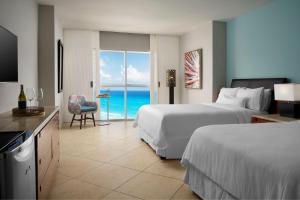 a hotel room with two beds and a view of the ocean at The Westin Resort & Spa Cancun in Cancún