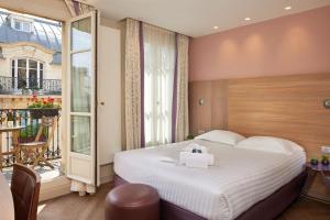 um quarto de hotel com uma cama e uma varanda em Hôtel de Sévigné em Paris
