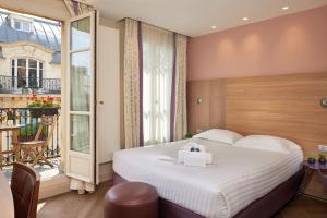 a hotel room with a bed and a balcony at Hôtel de Sévigné in Paris