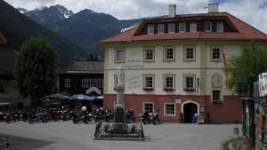 un grupo de motocicletas estacionadas frente a un edificio en Hotelchen Döllacher Dorfwirtshaus en Großkirchheim