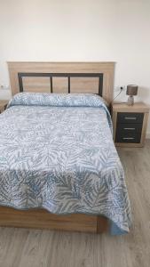 a bedroom with a bed with a blue and white comforter at Apartamentos NayDa N4 de 2 habitaciones in Mérida