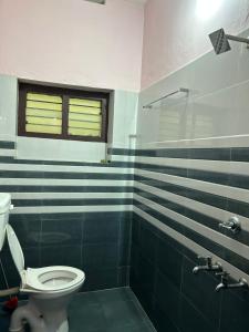 a bathroom with a toilet and a glass shower at Sowparnika duplex in Trivandrum