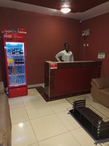 a man standing at a counter in front of a refrigerator at Beach View Hotel - Kisumu in Kisumu