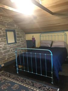 ein Schlafzimmer mit einem Bett und einer Steinmauer in der Unterkunft Springhouse 1803 in Hagerstown