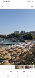 a group of umbrellas and boats on a beach at Seafront apartment in Ksamil +17 photos