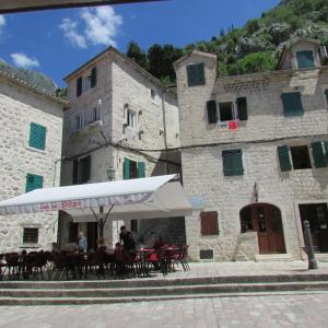 a restaurant with tables and chairs in front of a building at Apartments Popovic in Kotor