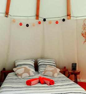 twee rode slippers op een bed in een kamer bij Le tipi à Marie, déconnectez- vous !!! in Cambounès