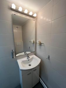un baño con lavabo y espejo en Apartments Pia, en Subotica 37 fotos más