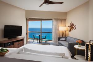 a bedroom with a bed and a living room with a television at The Westin Los Cabos Resort Villas in San José del Cabo