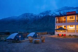 a group of tents and chairs in front of a building at Zostel Spiti in Kaza