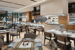 a restaurant with tables and a chef in the kitchen at Fairfield by Marriott Xi'an Chanba in Xi'an