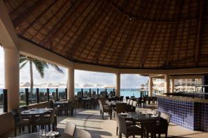 a restaurant with tables and chairs and a view of the ocean at The Westin Lagunamar Ocean Resort Villas & Spa Cancun in Canc&uacute;n