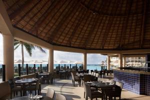a restaurant with tables and chairs and a view of the ocean at The Westin Lagunamar Ocean Resort Villas & Spa Cancun in Cancún