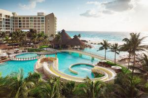 a resort with a large swimming pool next to the ocean at The Westin Lagunamar Ocean Resort Villas & Spa Cancun in Cancún