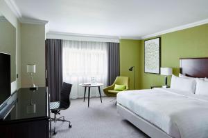 a hotel room with a bed and a table and chairs at Delta Hotels by Marriott Manchester Airport in Hale
