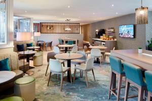 a restaurant with tables and chairs and a counter at Delta Hotels by Marriott Manchester Airport in Hale